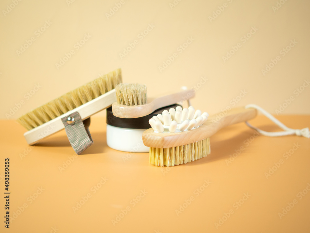 On an orange background, accessories for spa treatments, brushes for face and body massage On an orange background, accessories for spa treatments, brushes for face and body massage