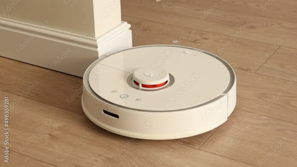 Robot vacuum cleaner vacuuming the floor in the apartment. Smart home with automated devices that simplify life. A smart vacuum cleaner cleans the floor. High quality FullHD footage Robot vacuum cleaner vacuuming the floor in the apartment. Smart home with automated devices that simplify life. A smart vacuum cleaner cleans the floor. High quality FullHD footage