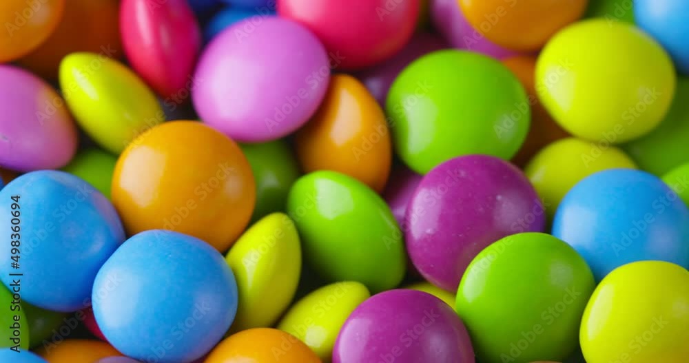 Slow motion close-up of round colorfull chocolate candies, dragee. Rotation and fall multicolored chocolate candies Slow motion close-up of round colorfull chocolate candies, dragee. Rotation and fall multicolored chocolate candies