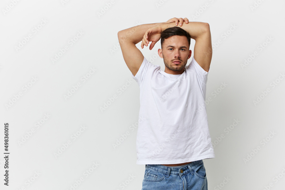 Young relaxed happy tanned handsome man in basic t-shirt folded hands overhead posing isolated on over white studio background. Copy space Banner Mockup. People emotions Lifestyle concept Young relaxed happy tanned handsome man in basic t-shirt folded hands overhead posing isolated on over white studio background. Copy space Banner Mockup. People emotions Lifestyle concept