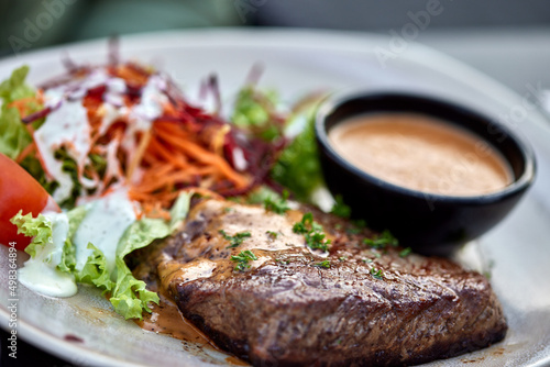 Plate with beef steak and fresh salad with mayonnaise