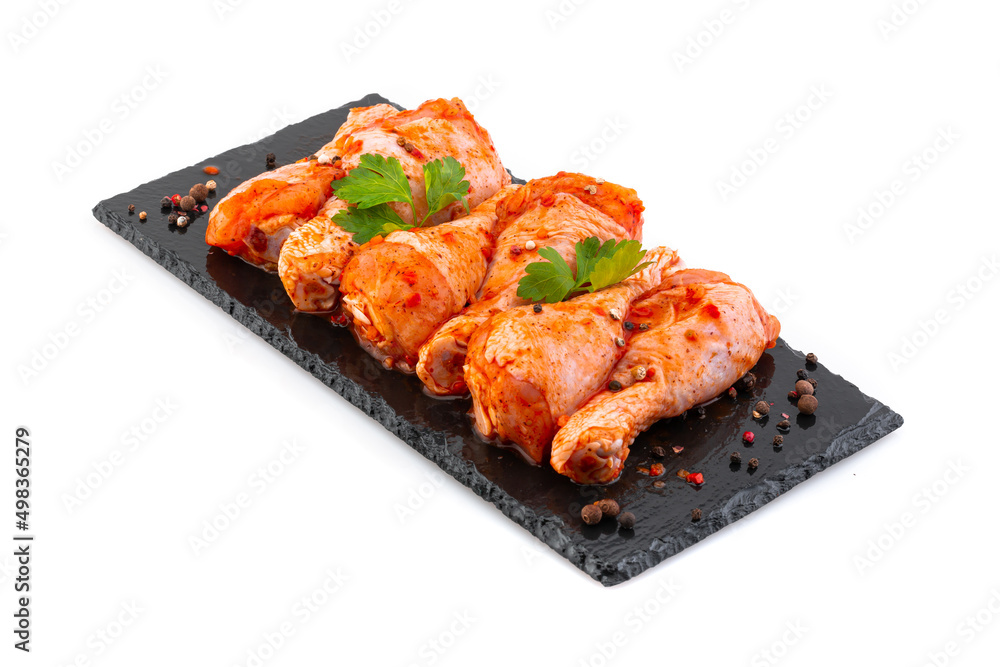 Сhicken drumsticks in marinade on a black plate Сhicken drumsticks in marinade on a black plate