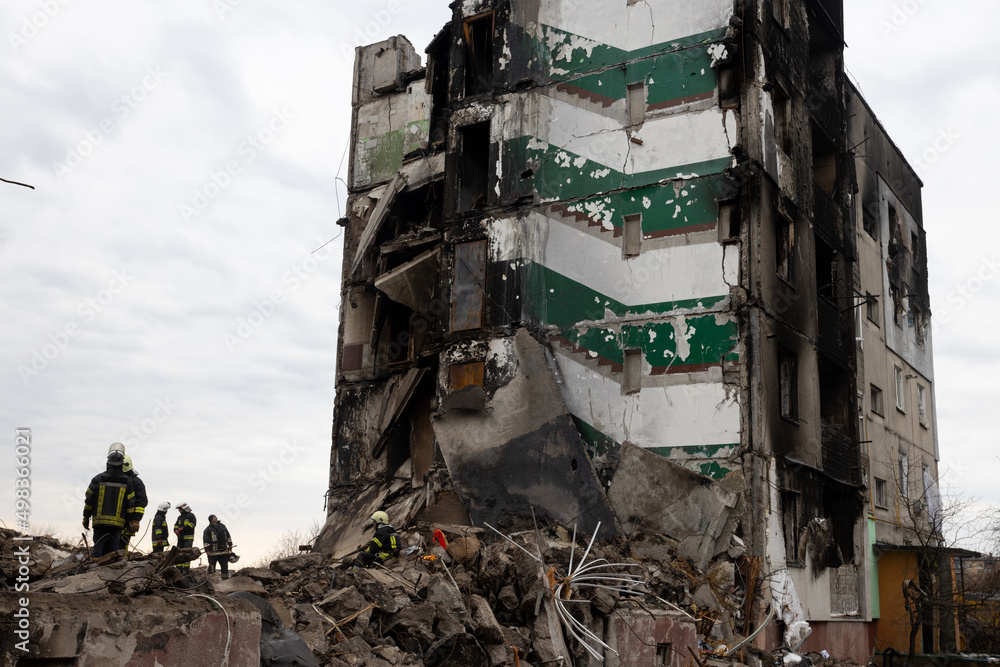 Bomberos trabajan en la limpieza de escombros y rescate de cuerpos de un edificio habitacional que fue destruido por un misil ruso en Bodoryanca Ucrania. - obrazy, fototapety, plakaty 