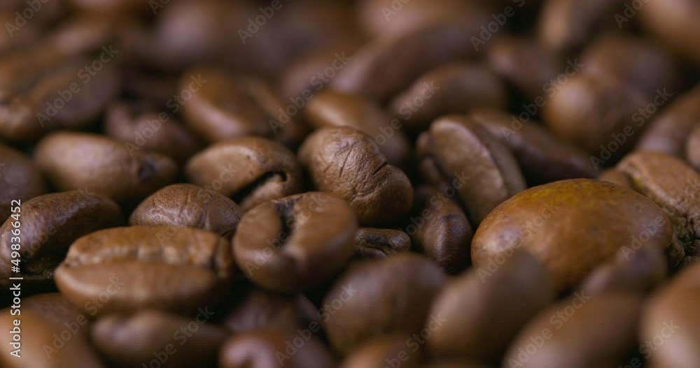 Slow motion close-up of whole roasted coffee beans. Rotation and fall сoffee beans. Slow motion close-up of whole roasted coffee beans. Rotation and fall сoffee beans.