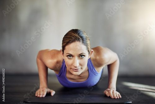 Raising her fitness game. Shot of an attractive young woman doing pushups as part of her workout.