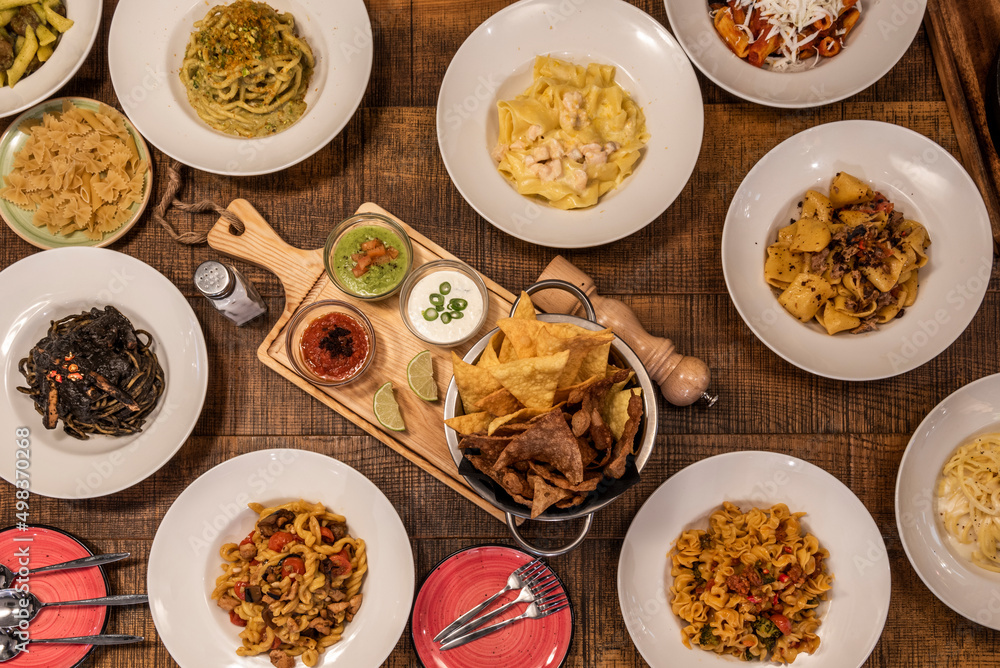 Set of Italian food dishes with parmigiana melanzane, pasta of all kinds, with pesto, with bolognese sauce, with black sauce and seafood and more