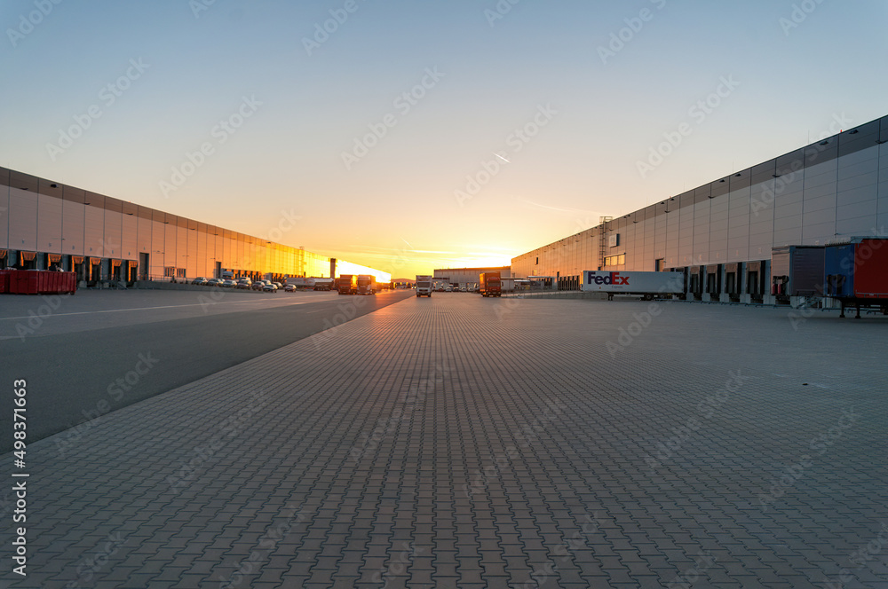 Logistics area with halls and trucks at sunset. Transport and storage of goods. Logistics area with halls and trucks at sunset. Transport and storage of goods.