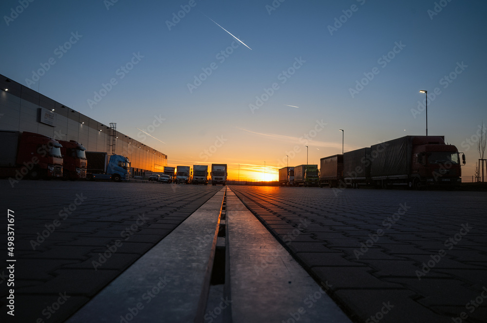 Logistics area with halls and trucks at sunset. Transport and storage of goods. Logistics area with halls and trucks at sunset. Transport and storage of goods.