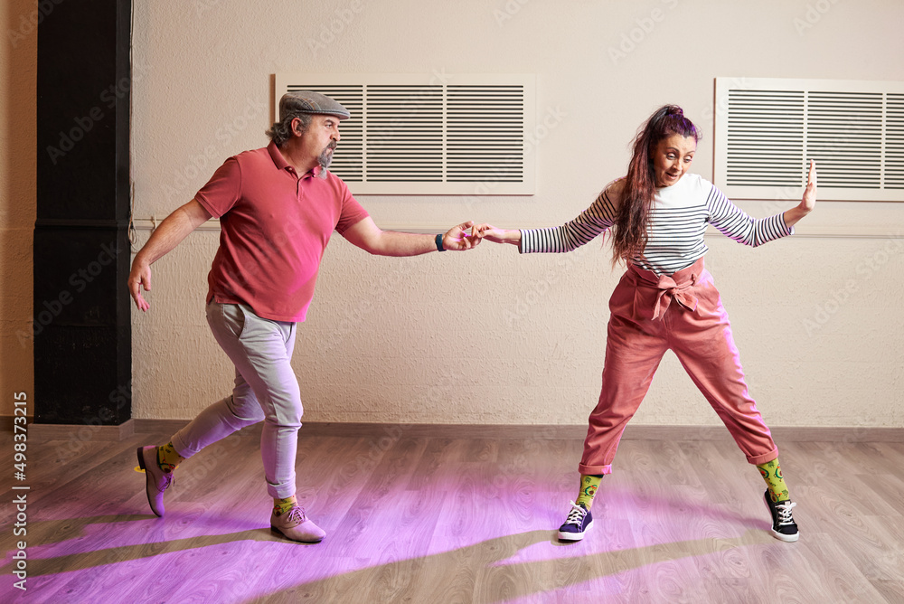 A senior adult couple dancing Lindy Hop in a studio