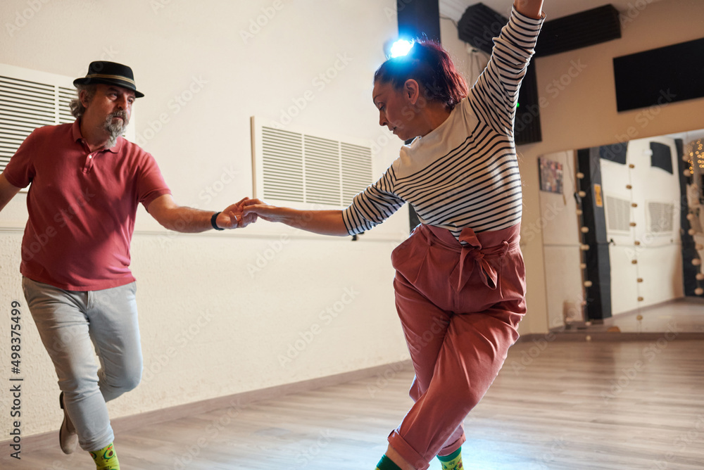 Fototapeta premium A man and a woman dancing Lindy Hop in a dance studio