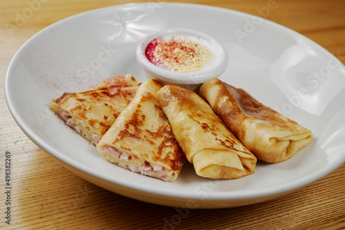 pancakes with cheese and ham, served with sauce
