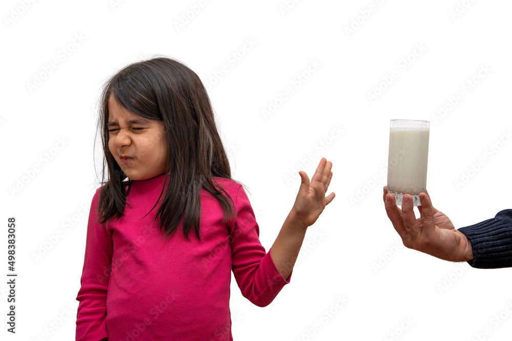 Elementary school girl turns down a glass of milk offered to her on a white background Elementary school girl turns down a glass of milk offered to her on a white background