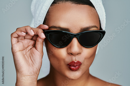 Im feeling real cute. Cropped shot of a beautiful young woman posing with sunglasses and red lipstick.