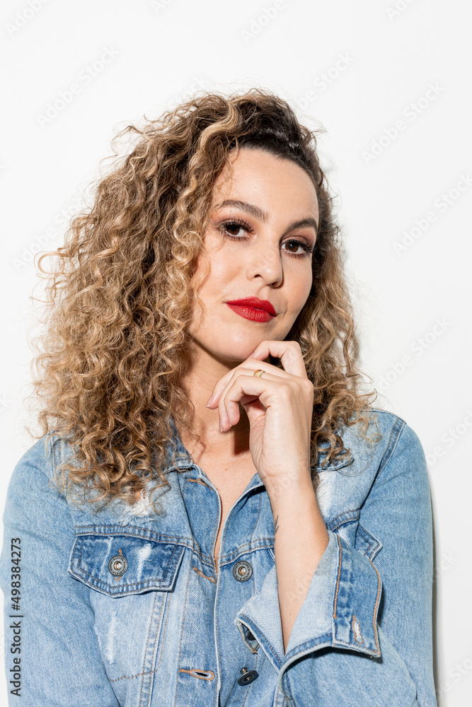 Studio shot of proud young girl with perfect light brown skin and beautiful curly hair in empowerment pose on a white background. Studio shot of proud young girl with perfect light brown skin and beautiful curly hair in empowerment pose on a white background.