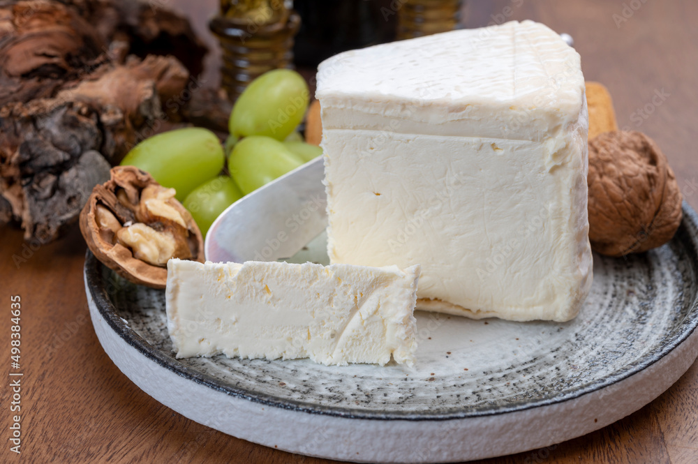Delice de Bourgogne French cow's milk cheese from Burgundy region of France served with grapes, wine and walnuts Delice de Bourgogne French cow's milk cheese from Burgundy region of France served with grapes, wine and walnuts
