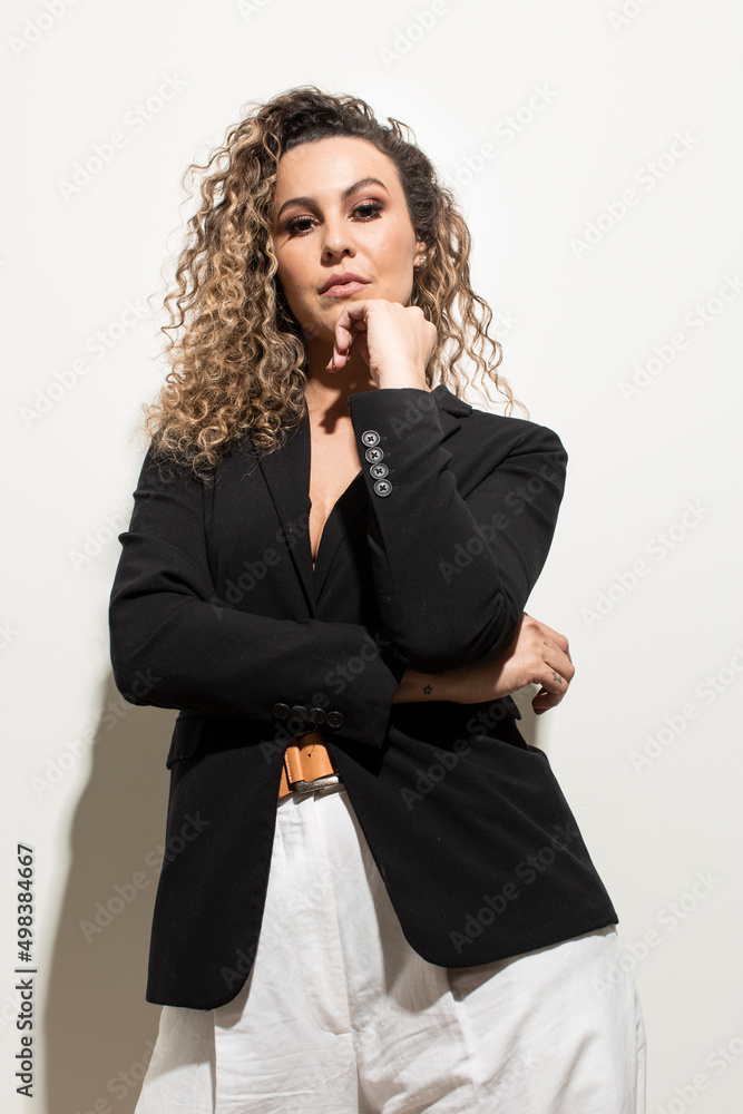 Studio shot of proud young girl with perfect light brown skin and beautiful curly hair in empowerment pose on a white background. Studio shot of proud young girl with perfect light brown skin and beautiful curly hair in empowerment pose on a white background.