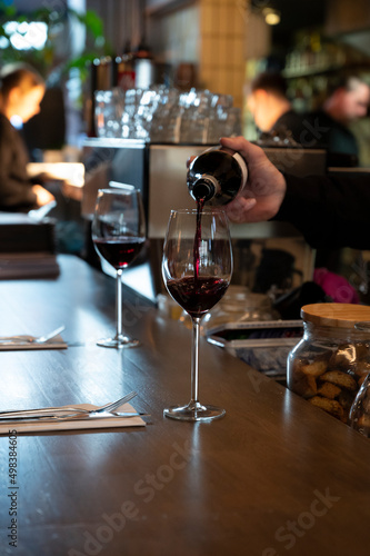 Pouring of dry Spanish tempranillo red wine in glass in Spanish bogeda restaurant