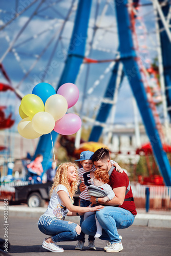 Canvas-taulu young family with kids having fun on funfair, amusement park at summer day with