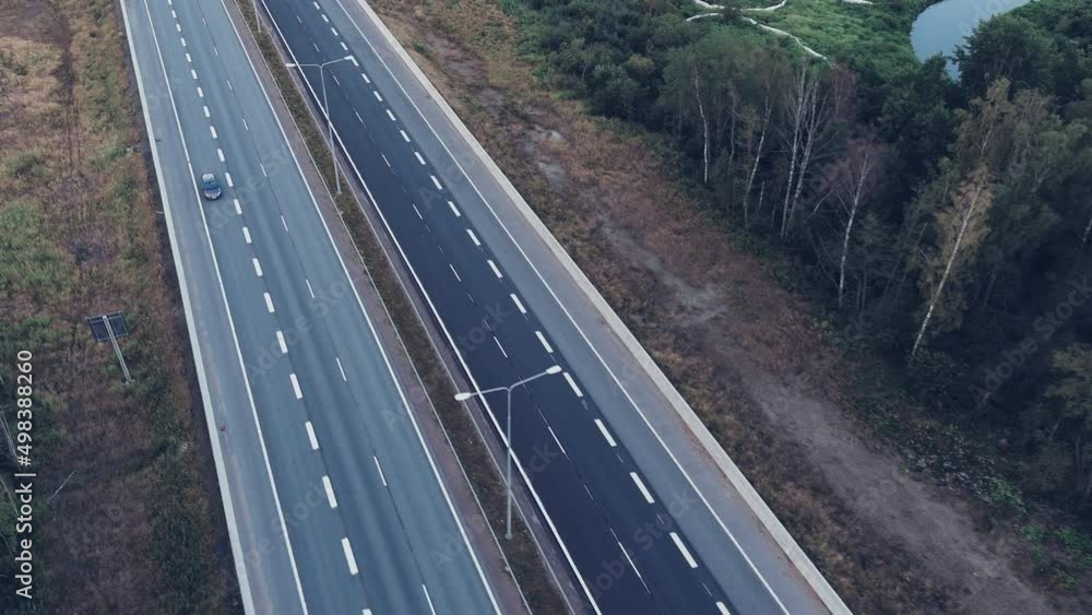 Aerial view of autumn road with cars. Drone view of a highway in the autumn forest. Autumn road in the forest. Air landscape. Aerial view of autumn road with cars. Drone view of a highway in the autumn forest. Autumn road in the forest. Air landscape.