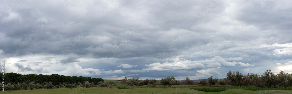 Storm clouds cover the landscape. Tragic gloomy sky. Panorama.