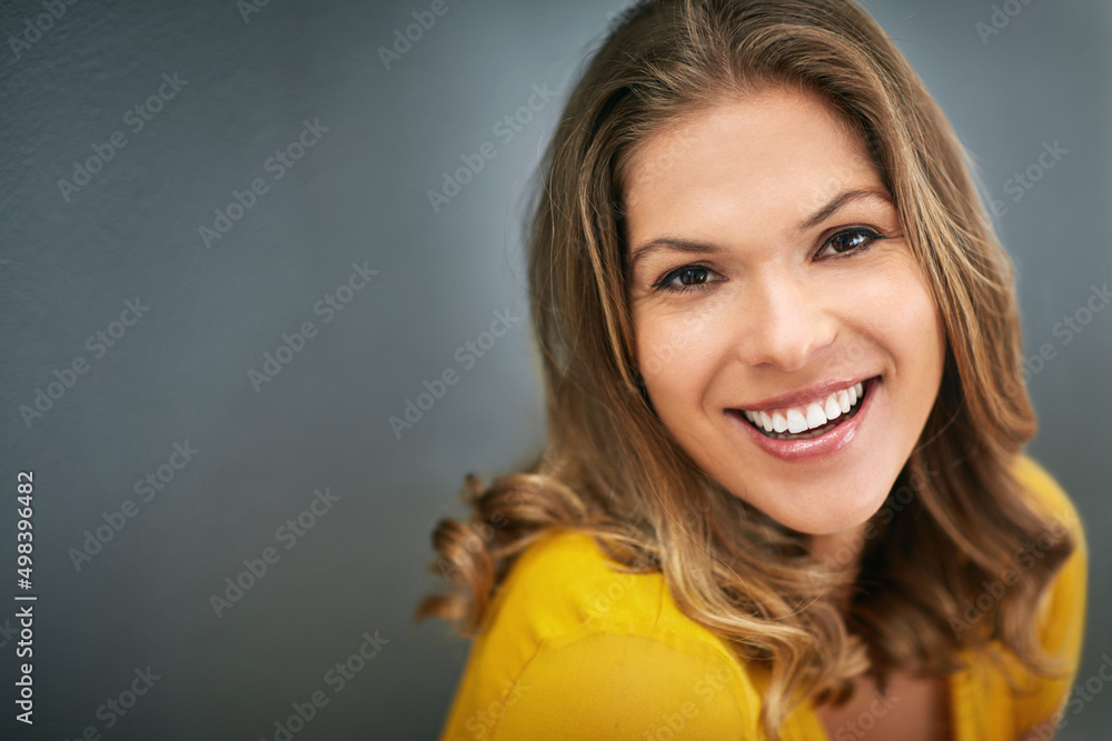 The power of confidence is limitless. Shot of a young woman posing against a gray wall. The power of confidence is limitless. Shot of a young woman posing against a gray wall.