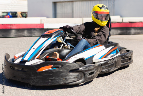 Happy cheerful positive smiling female go-cart racer at kart circuit outdoors