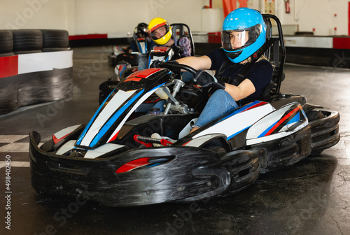 Glad woman driving sport car for karting in a circuit lap in sport club