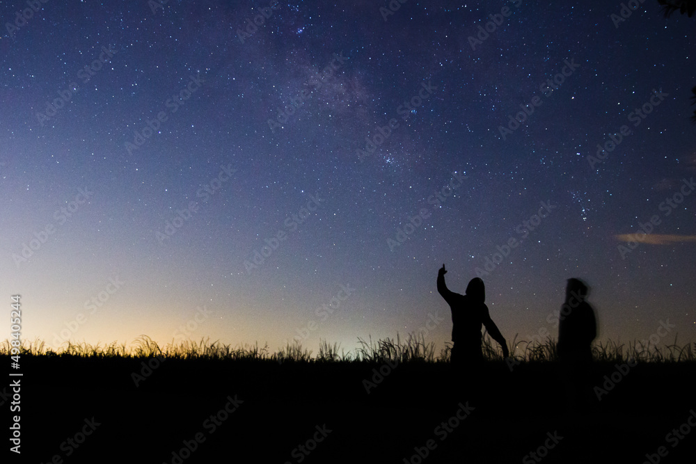 People standing in front of milky way