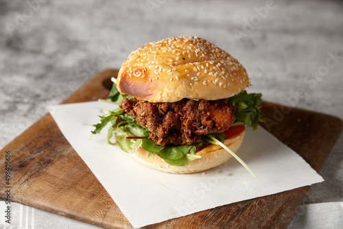 Close up of tasty fried chicken burger roll on board photo