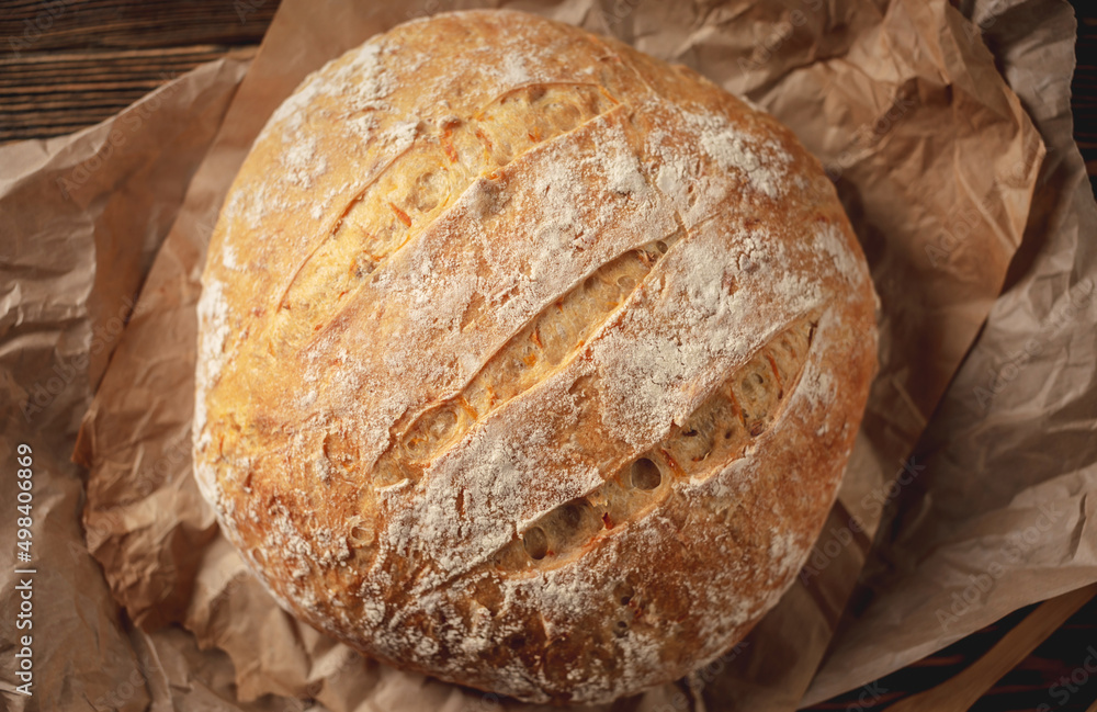 Homemade natural bread with a Golden crust on a napkin on an old wooden background. Baking bakery products. Rustic style Homemade natural bread with a Golden crust on a napkin on an old wooden background. Baking bakery products. Rustic style