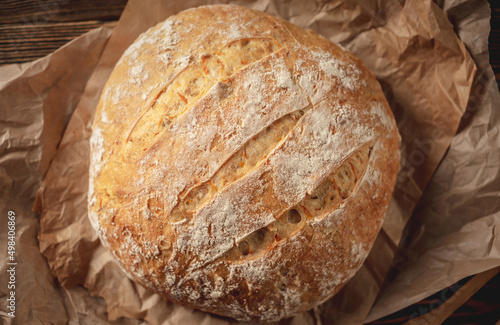 Homemade natural bread with a Golden crust on a napkin on an old wooden background. Baking bakery products. Rustic style