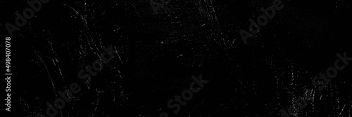 Dark creative background - rough linen canvas unevenly covered with black primer, reflections of light. Toning, blurring, selective focus.