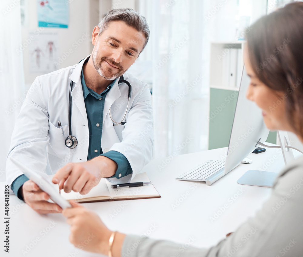 Its easier to explain like this. Shot of a mature doctor using a digital tablet during a consultation with a patient in a medical office. Its easier to explain like this. Shot of a mature doctor using a digital tablet during a consultation with a patient in a medical office.