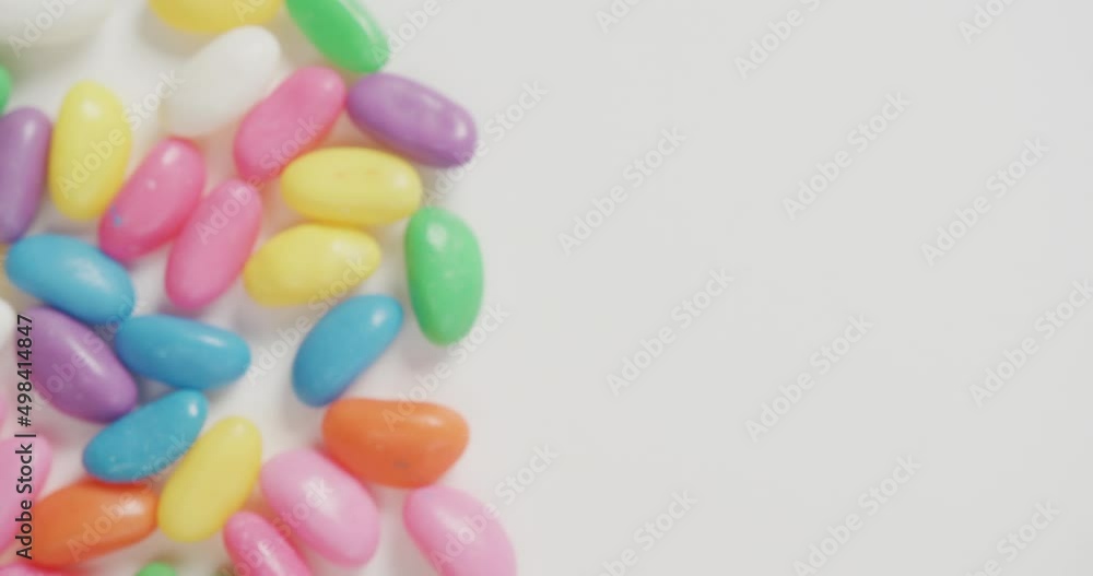 Video of close up of multi coloured sweets with copy space over white background Video of close up of multi coloured sweets with copy space over white background