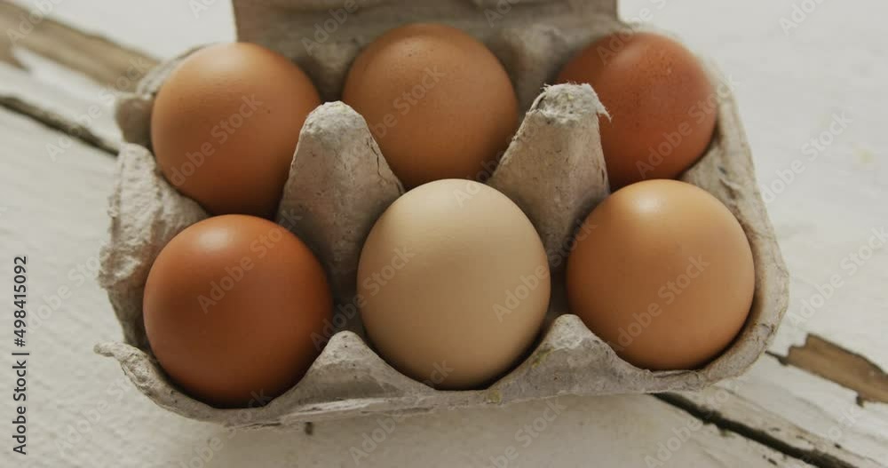 Video of overhead view of brown eggs in egg carton on rustic background Video of overhead view of brown eggs in egg carton on rustic background