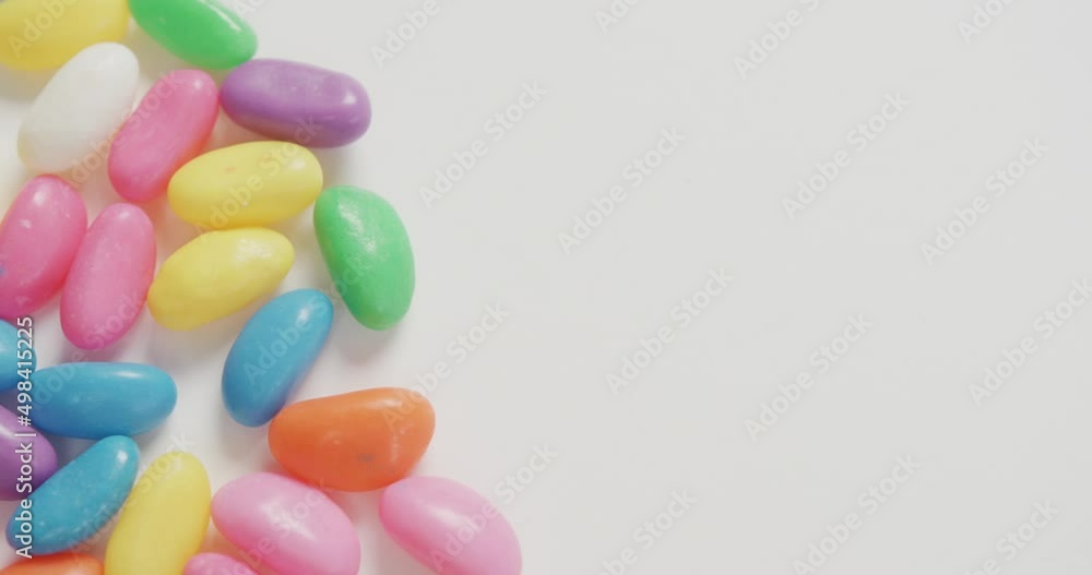 Video of close up of multi coloured sweets with copy space over white background Video of close up of multi coloured sweets with copy space over white background