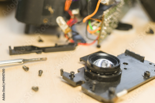 Disassembled compact camera. Internal parts of the broken camera being repaired in the workshop. Selective focus