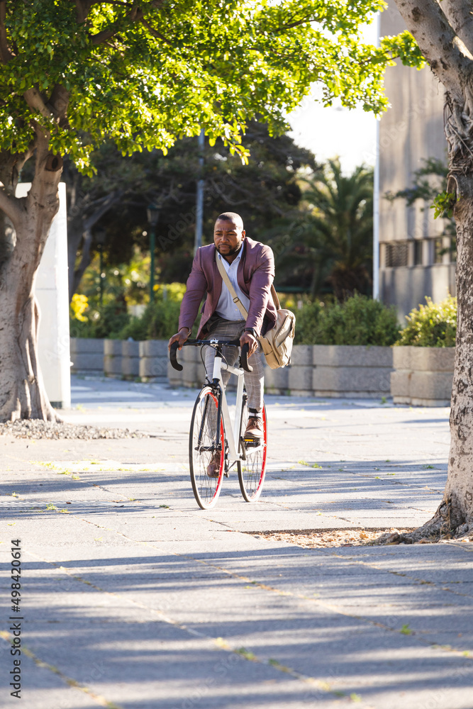 African american businessman riding a bicycle on the street on the go to office African american businessman riding a bicycle on the street on the go to office