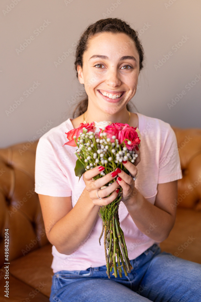 Portrait of caucasian woman holding a flower bouquet smiling sitting on the couch at home Portrait of caucasian woman holding a flower bouquet smiling sitting on the couch at home