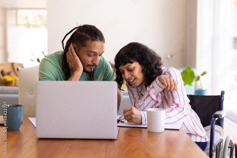 African american disabled woman and her husband calculating finances together at home African american disabled woman and her husband calculating finances together at home