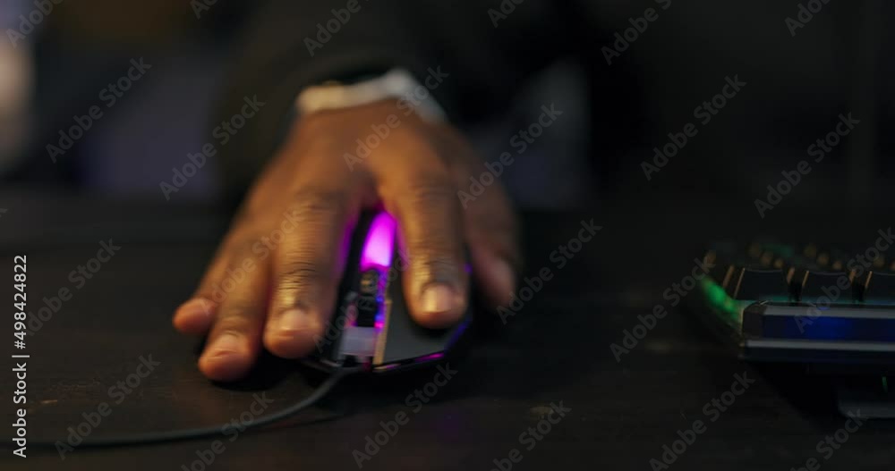 Close-up of a man's hand with dark skin placed on a led colored computer mouse, gamer is playing shooting games. Close-up of a man's hand with dark skin placed on a led colored computer mouse, gamer is playing shooting games.