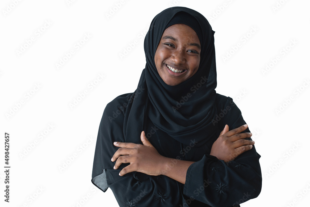 Happy African Muslim pre-teen wearing black hijab and crossed arms, smiling at camera, isolated on white background Happy African Muslim pre-teen wearing black hijab and crossed arms, smiling at camera, isolated on white background