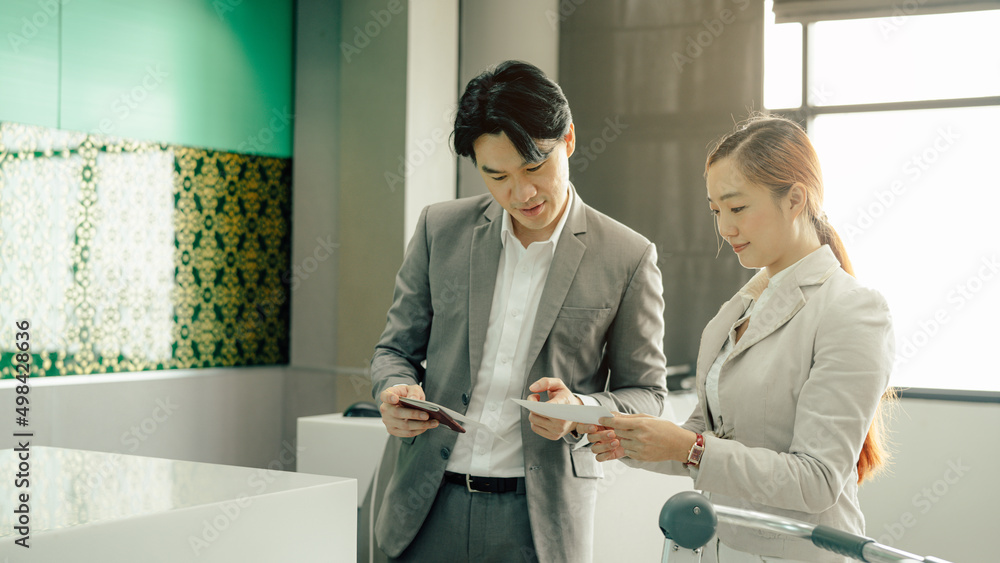 Fototapeta premium Young business woman at check-in counter with airlines staff. Airline transportation and tourism concept.