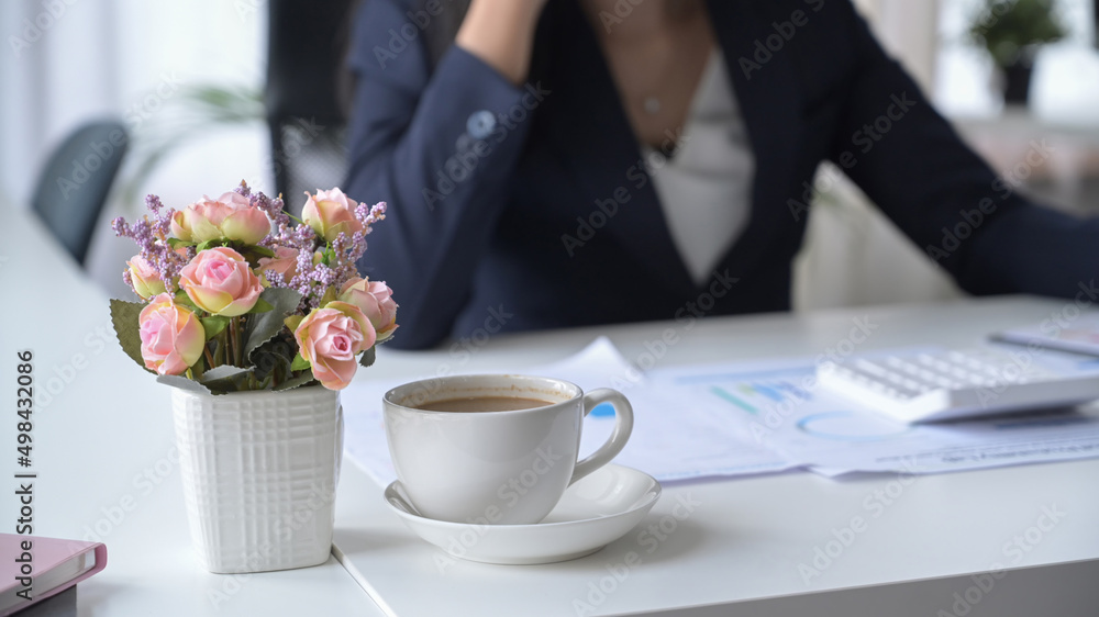 Coffee cup, flower pot and financial documents on white office desk. Coffee cup, flower pot and financial documents on white office desk.