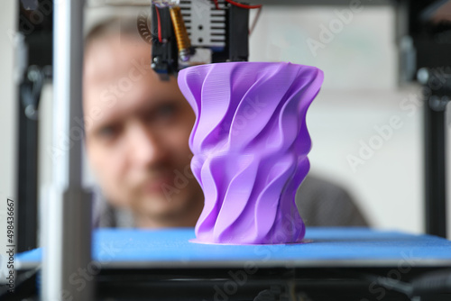 An engineer controls the machine. Layer-by-layer 3D printing of a polymer plastic part. Sample production