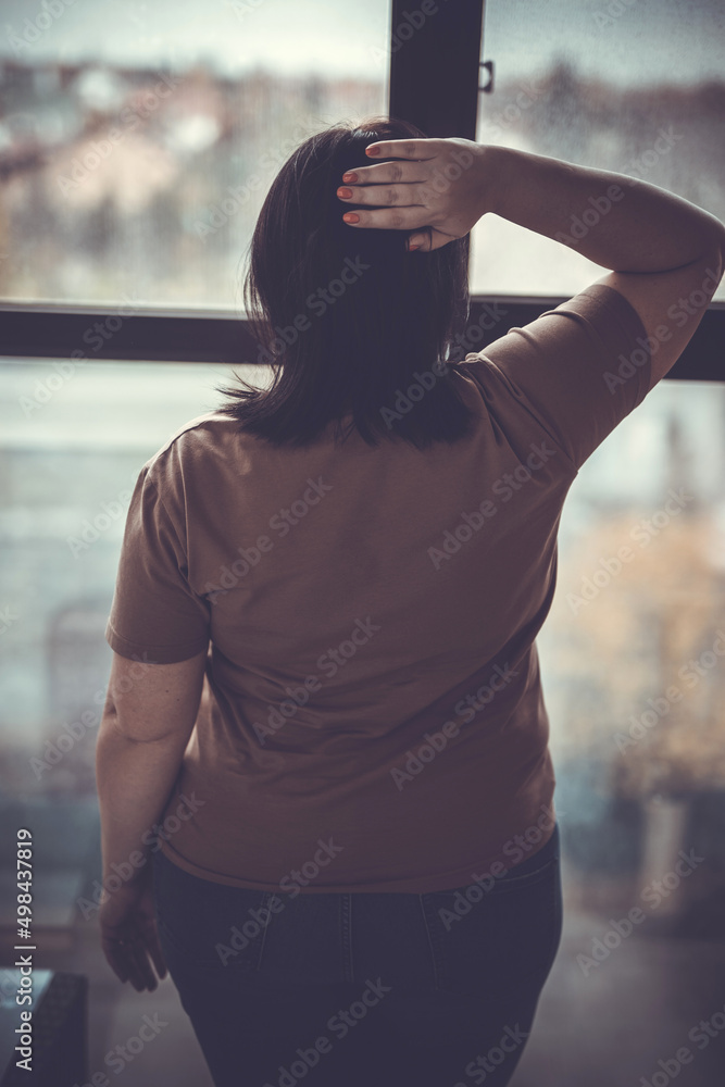 A young woman stands near the observation windows and looks at the city. A young woman stands near the observation windows and looks at the city.