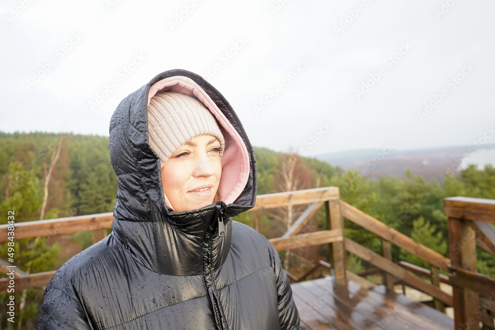 A young girl in a black jacket enjoys the sun on the viewpoint of the Curonian Spit, Kaliningrad. A young girl in a black jacket enjoys the sun on the viewpoint of the Curonian Spit, Kaliningrad.