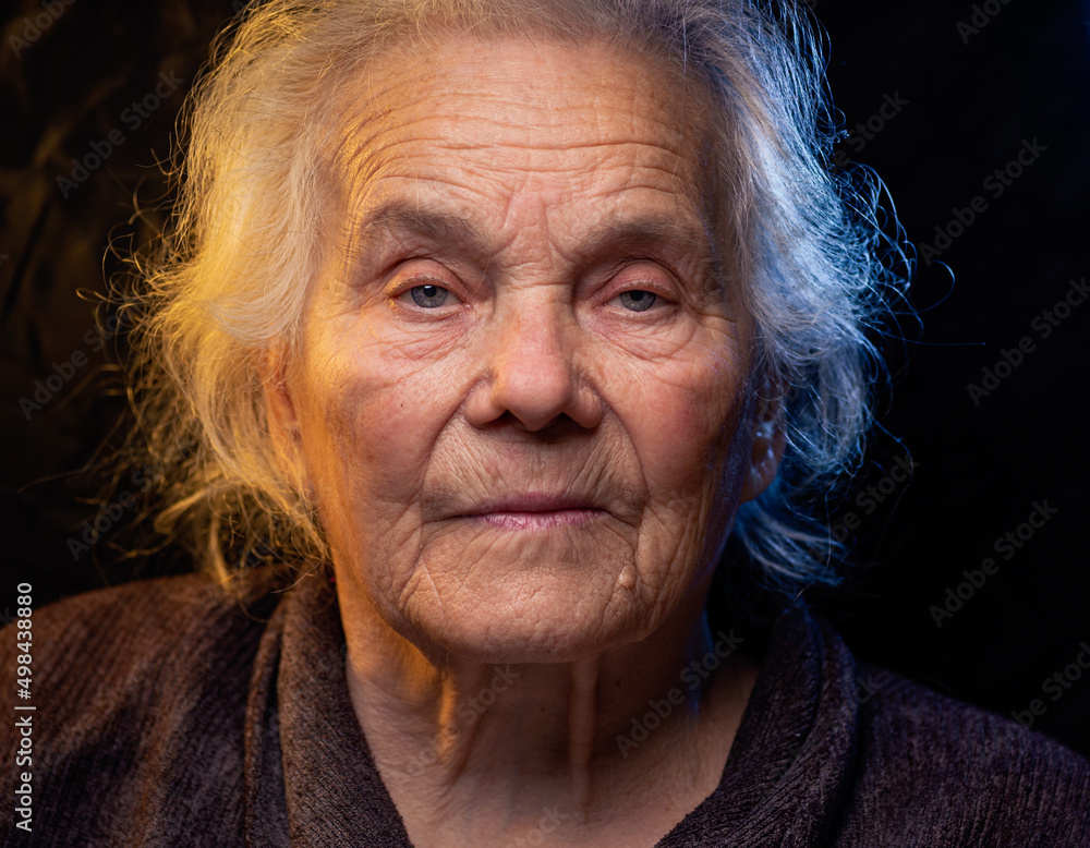 custom made wallpaper toronto digitalPortrait of beautiful elderly old woman in colorful bright lights blue and yellow, , 70s, grandmother,  on black background., positive, smiling at camera, happy, studio, Close up, gray hair, caucasian