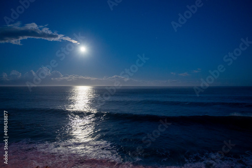 Moonlight path on water of Atlantic ocean at night on Tenerife and dark blue sky with full Moon and stars © barmalini