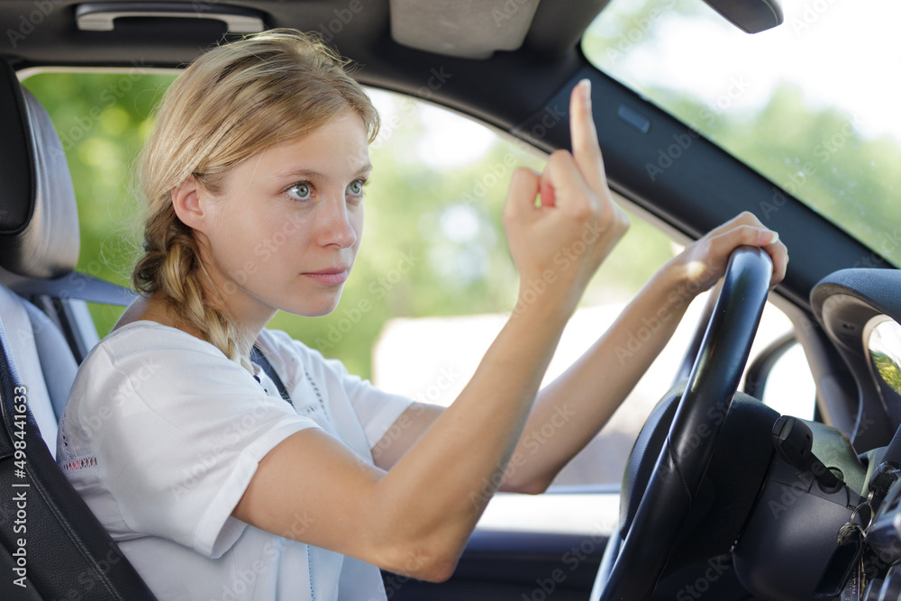 Naklejka premium young woman shows middle finger while driving